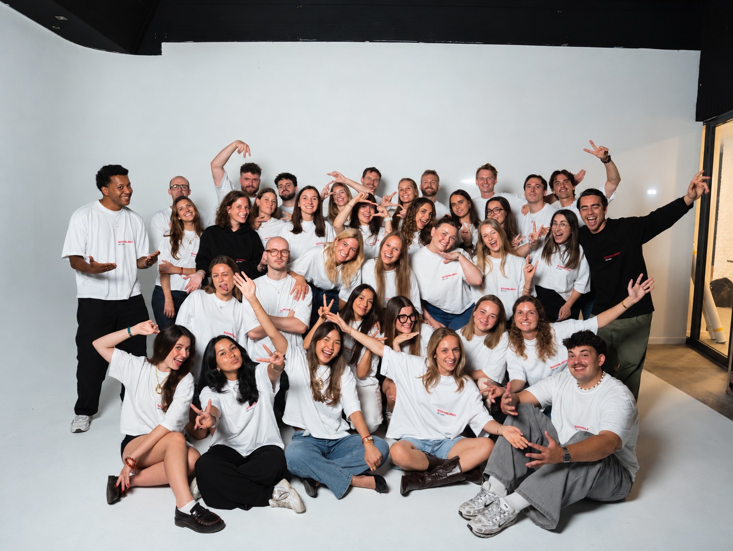 L’équipe en t-shirts blancs posant dans un studio sur fond blanc
