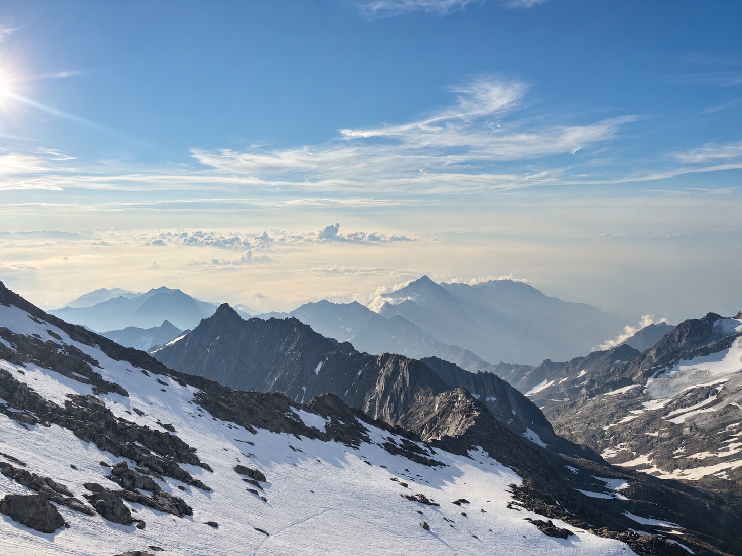 Panorama de crêtes enneigées au-dessus d’une mer de nuages